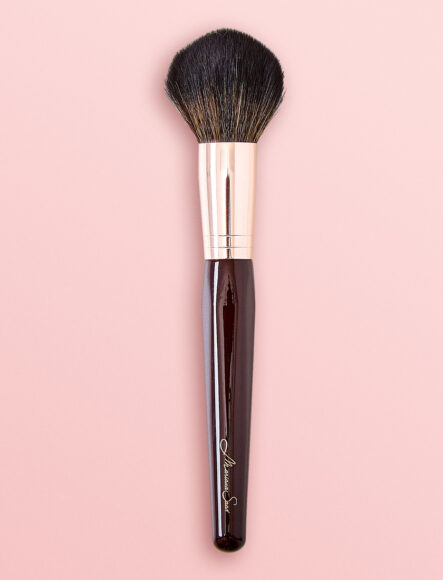 Pincel de maquiagem large powder em um fundo rosa claro 